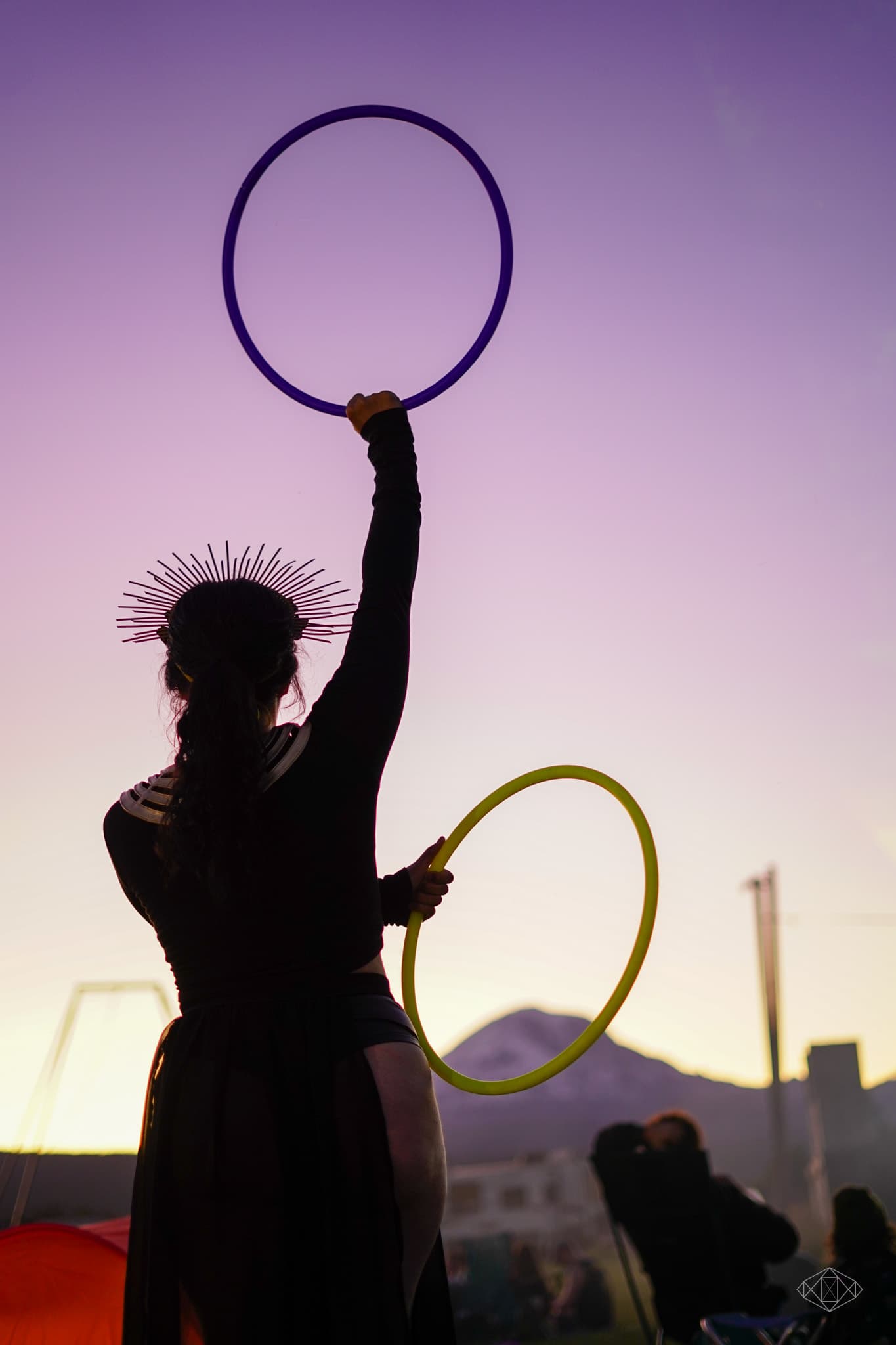 Jess performing with her hoops, with one held high above her head. Her costume giving to the Statue of Liberty vibes of the pose.